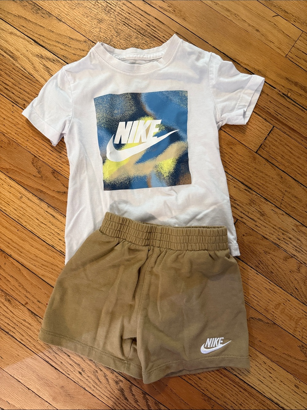 Nike White Tee with Blue & Yellow Logo and Tan Shorts